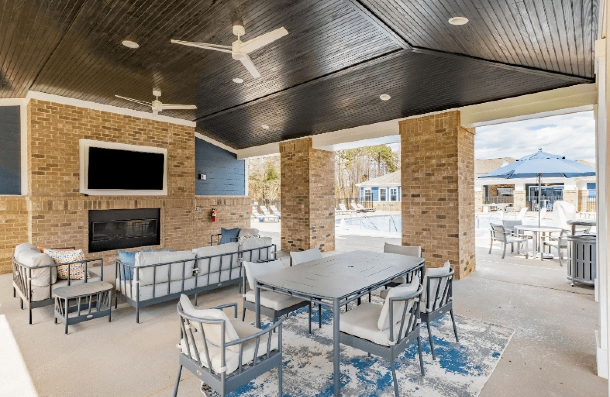 Hawthorne at Westport outdoor lounge area with seating, a fireplace, and large TV
